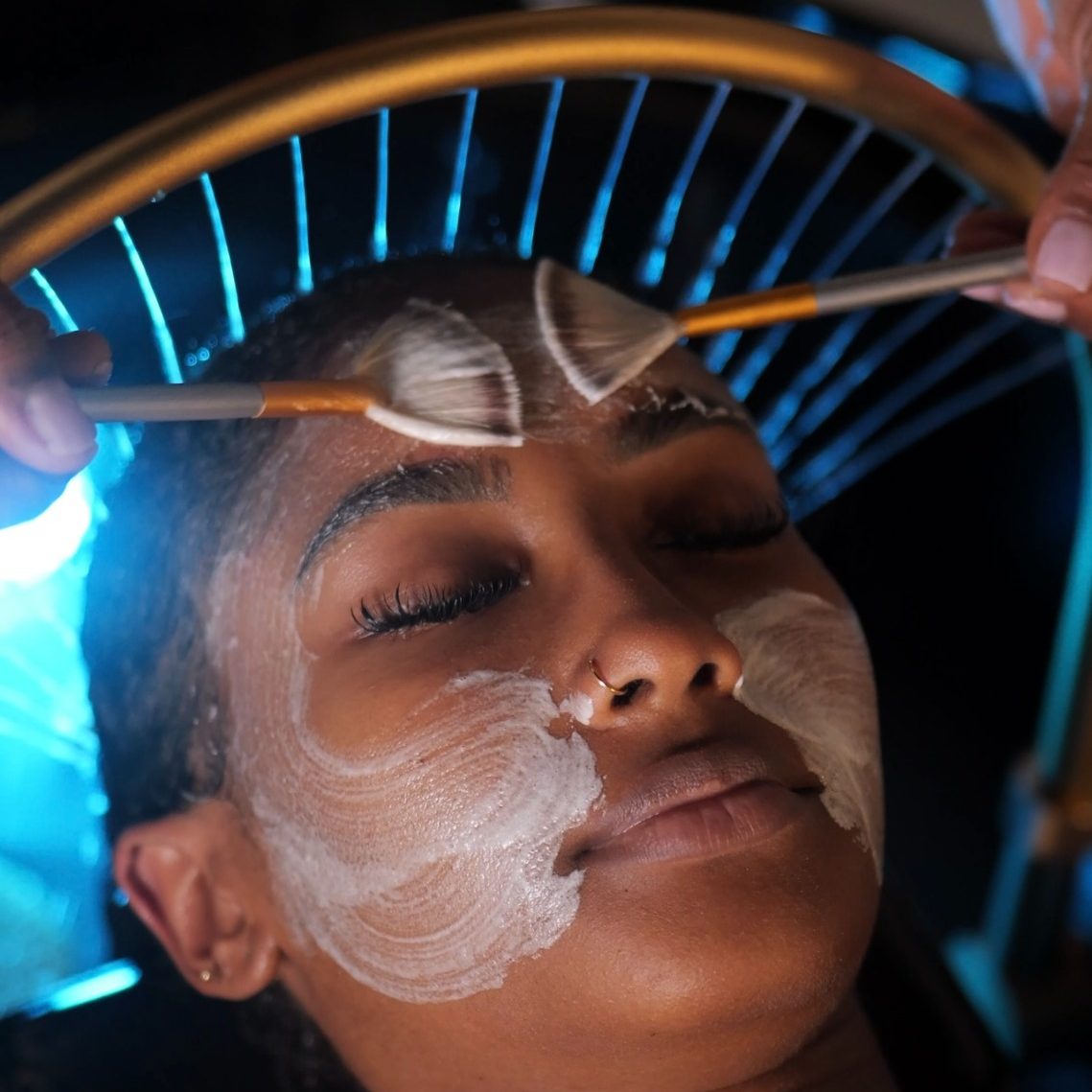 Femme allongée avec un bandeau sur les yeux, recevant un soin au spa.