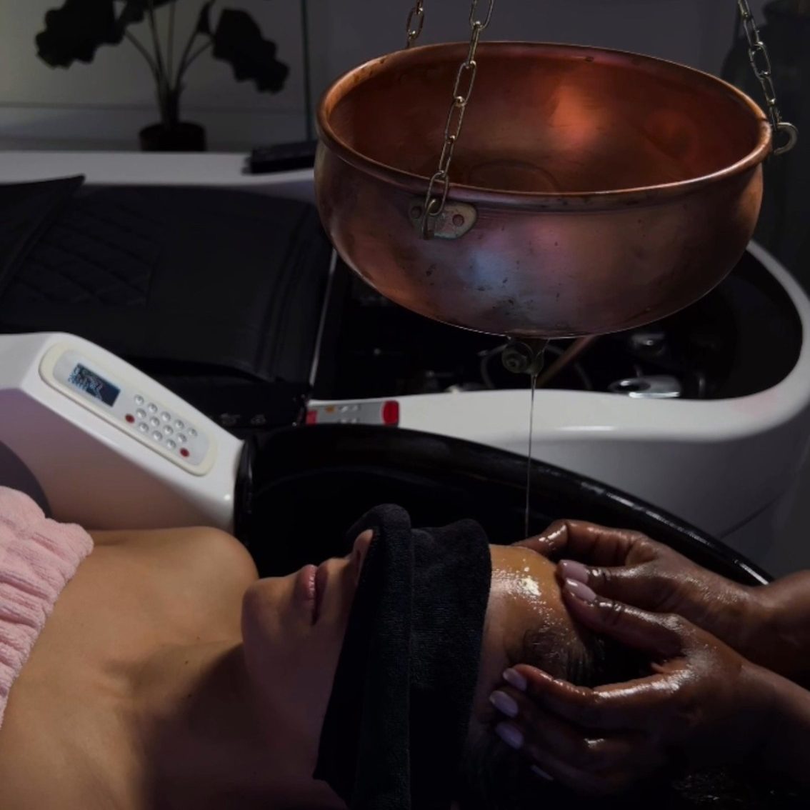 Femme allongée avec un bandeau sur les yeux, recevant un soin au spa.